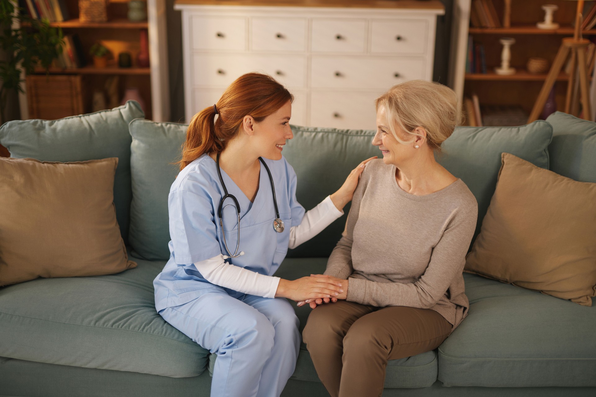 Caring nurse providing home support to senior